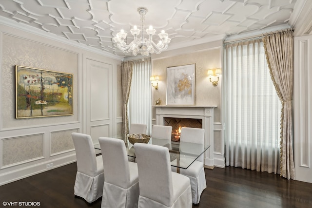 dining area with dark wood-type flooring, ornamental molding, and a chandelier