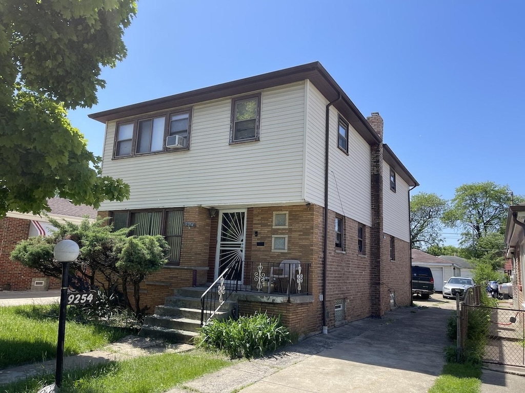 9254 S Burnside Ave, Chicago, IL 60619 - view of front facade featuring a chimney, brick siding, and cooling unit