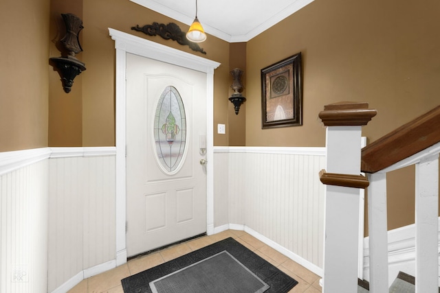 foyer entrance featuring light tile patterned flooring and ornamental molding