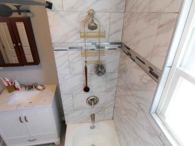 bathroom with vanity and tiled shower / bath combo