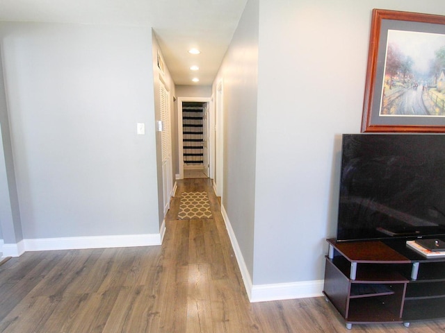 corridor with hardwood / wood-style floors