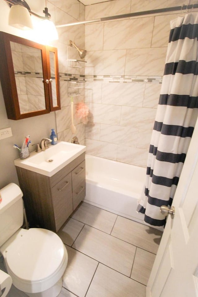 full bathroom featuring tile patterned flooring, vanity, shower / tub combo with curtain, and toilet