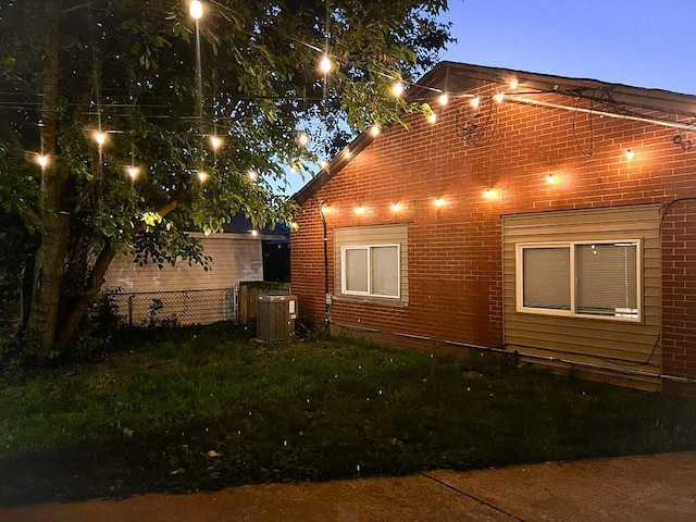 view of property exterior with cooling unit and a lawn