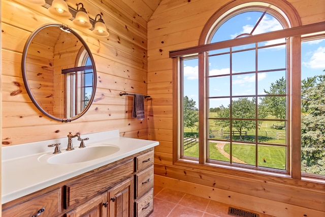 bathroom with wood walls, tile flooring, and vanity