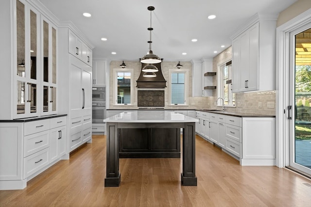 kitchen featuring a center island, white cabinets, and decorative light fixtures