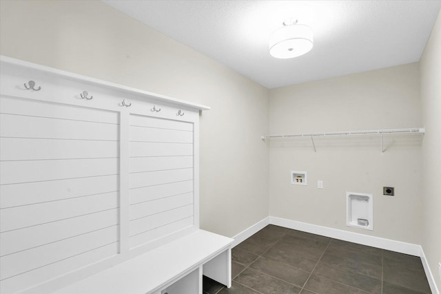 laundry area with washer hookup, electric dryer hookup, a textured ceiling, and dark tile patterned flooring