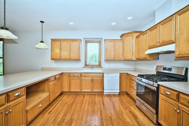 kitchen featuring pendant lighting, white dishwasher, sink, gas range, and light hardwood / wood-style flooring