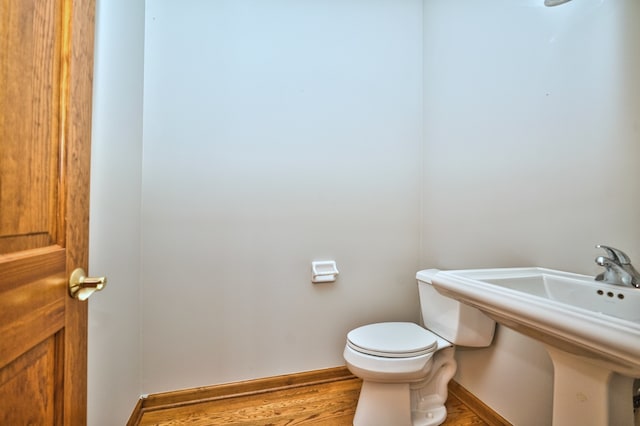 bathroom with hardwood / wood-style flooring and toilet