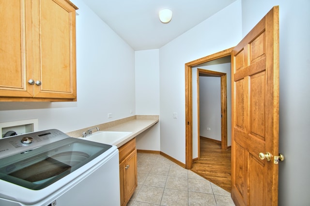 washroom with light tile patterned floors, washer / clothes dryer, cabinets, and sink