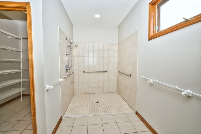 bathroom with a tile shower and tile patterned floors