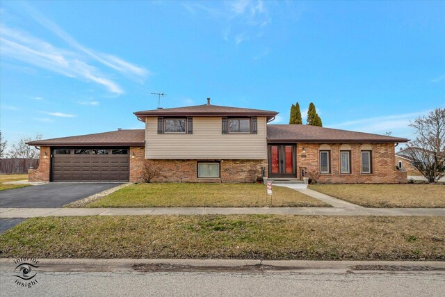 split level home featuring a garage and a front lawn