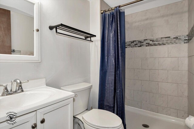 bathroom featuring toilet, walk in shower, and vanity