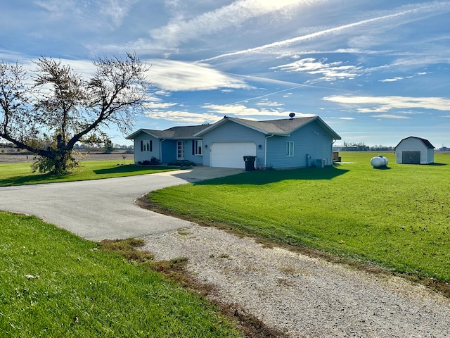 single story home with a front yard, a storage unit, and a garage