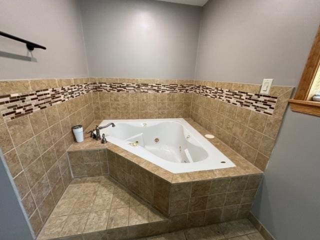 bathroom with tiled tub and tile patterned floors