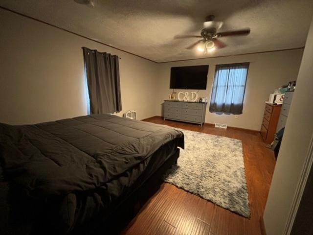 bedroom with wood-type flooring, a textured ceiling, and ceiling fan