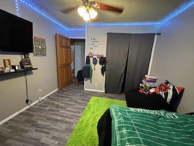 bedroom featuring ceiling fan, hardwood / wood-style flooring, and a textured ceiling