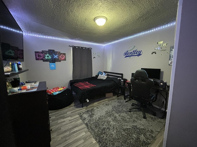 bedroom featuring hardwood / wood-style flooring and a textured ceiling