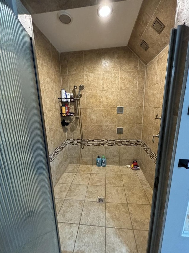 bathroom featuring lofted ceiling and tile patterned flooring