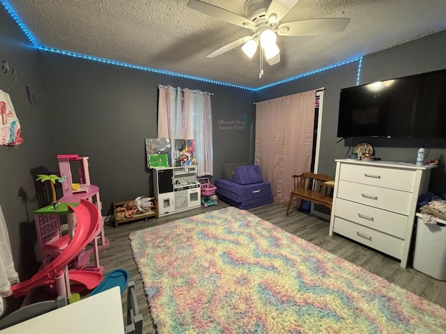 bedroom featuring wood-type flooring, ceiling fan, and a textured ceiling