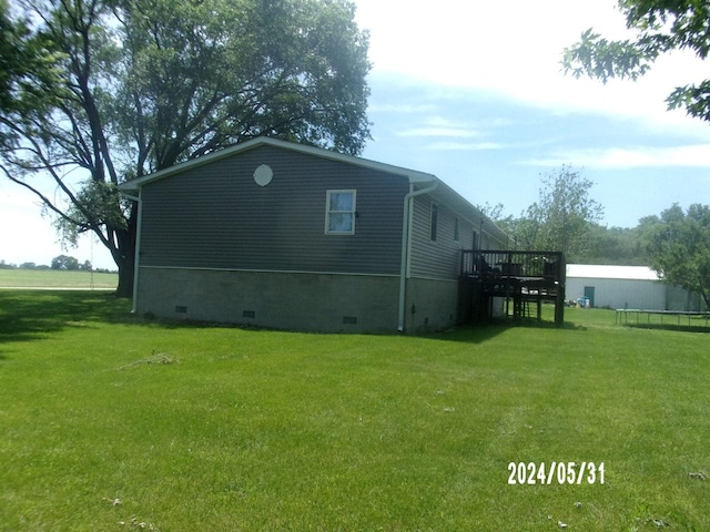 view of home's exterior with a lawn and a deck