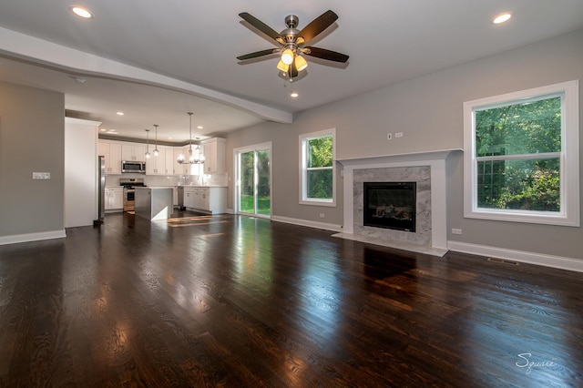 unfurnished living room with dark hardwood / wood-style floors, ceiling fan, and a premium fireplace