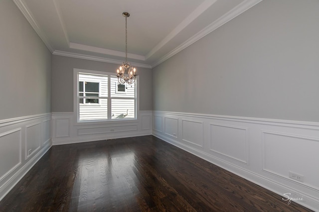 spare room featuring dark hardwood / wood-style flooring, a notable chandelier, and a tray ceiling