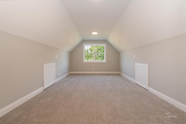 additional living space with vaulted ceiling and light carpet