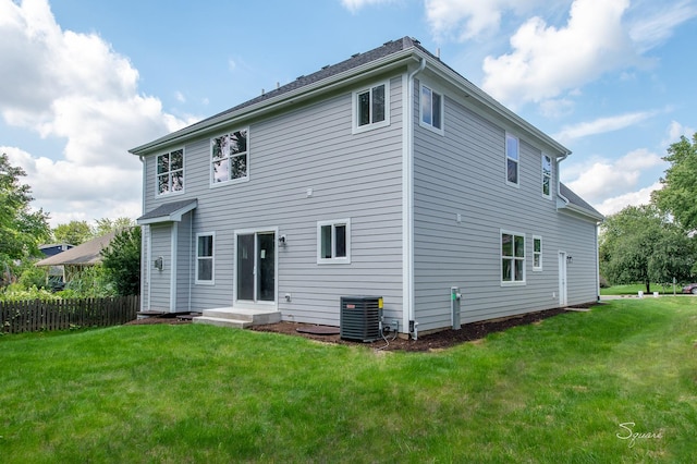 back of house featuring cooling unit and a lawn