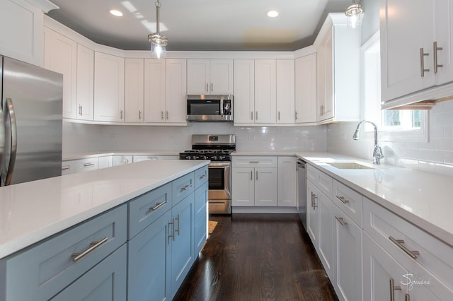 kitchen with white cabinetry, appliances with stainless steel finishes, sink, and hanging light fixtures