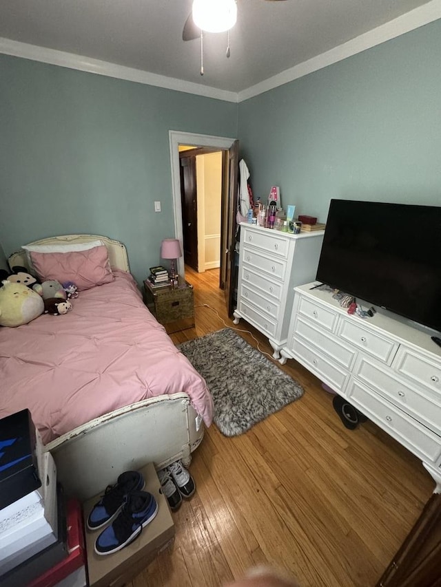 bedroom with ceiling fan, wood-type flooring, and ornamental molding