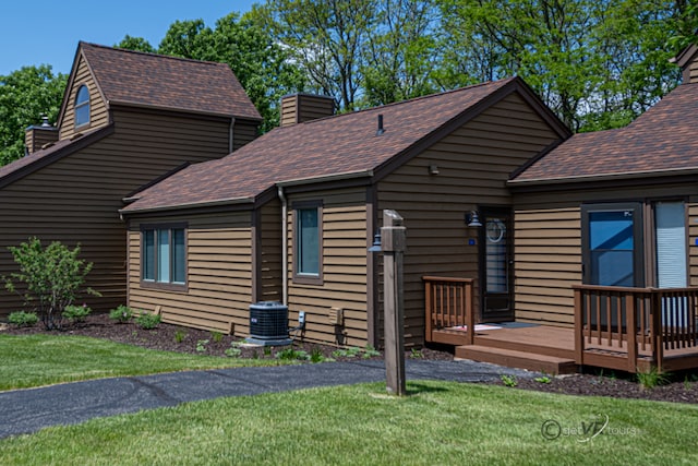 log cabin with a front lawn, central AC unit, and a deck