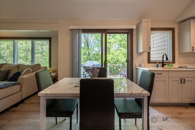 dining space featuring light hardwood / wood-style floors, a wealth of natural light, and sink