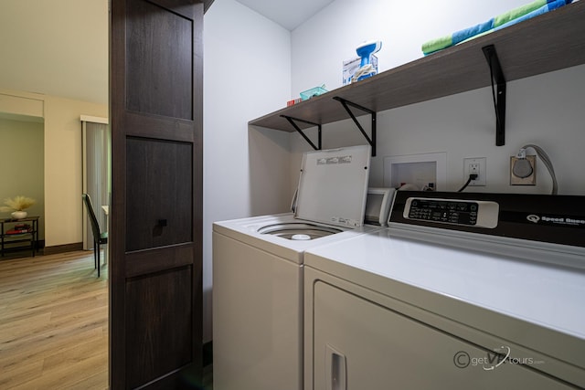 clothes washing area featuring washing machine and dryer and light wood-type flooring