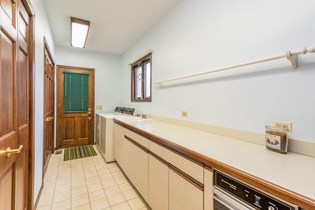 laundry room featuring cabinets, light tile patterned floors, washer and clothes dryer, and sink