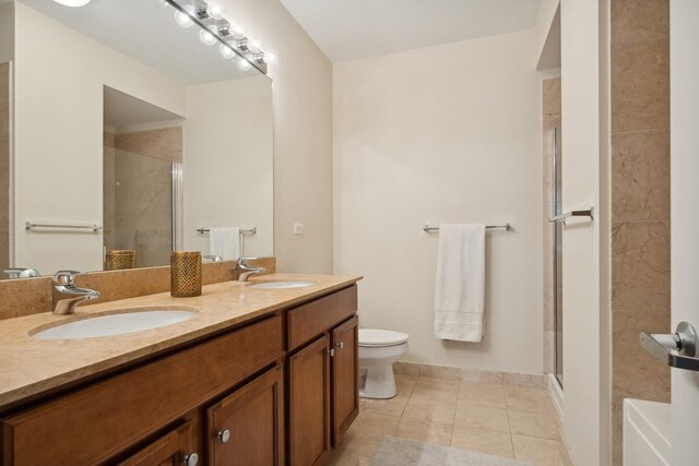 bathroom with tile patterned flooring, vanity, a shower with door, and toilet