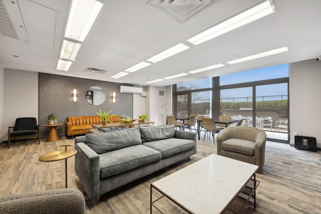 living room featuring a wall mounted air conditioner, hardwood / wood-style floors, and expansive windows