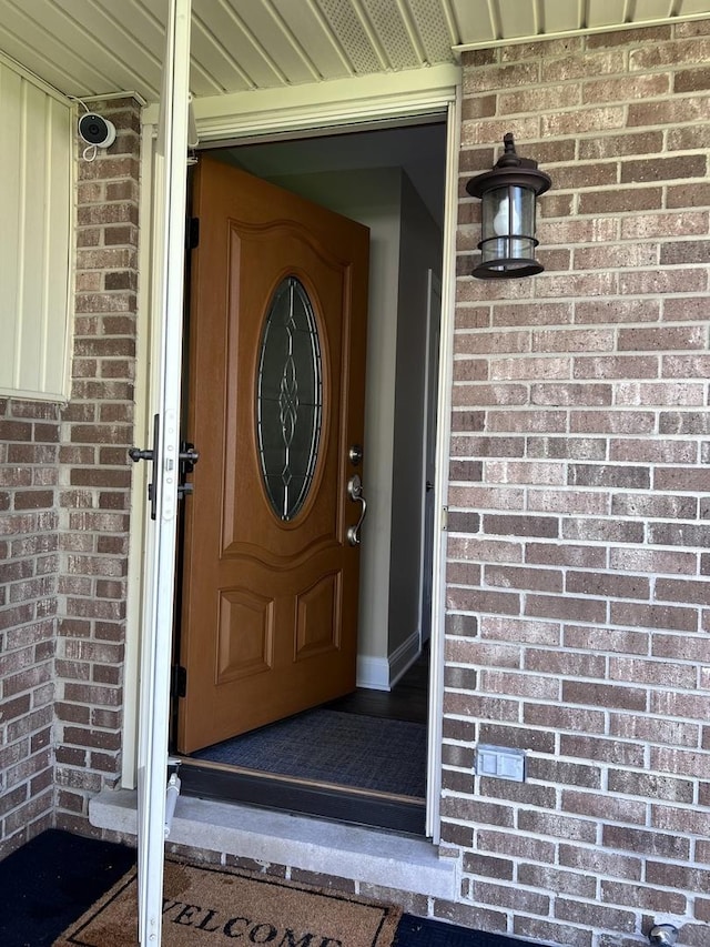 view of exterior entry featuring brick siding