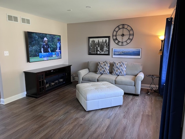 living room with visible vents, dark wood-style flooring, and baseboards