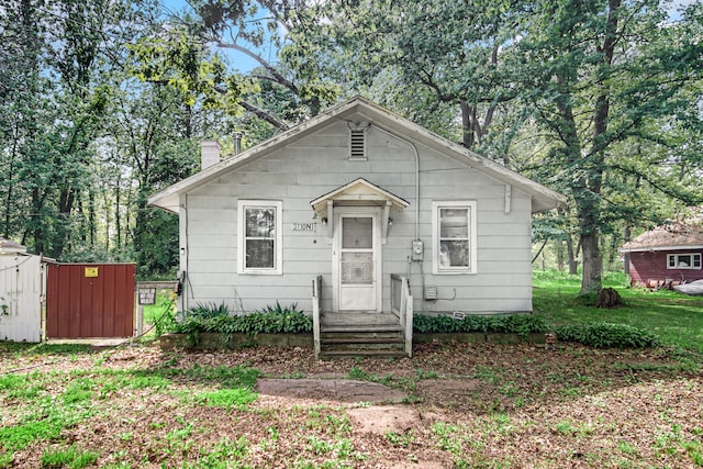 bungalow-style home featuring a storage shed