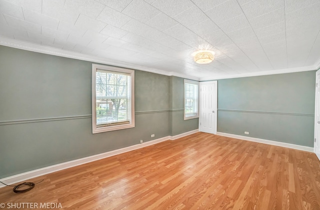 unfurnished room with a wealth of natural light, crown molding, and light hardwood / wood-style floors