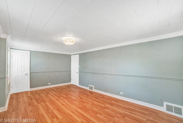 spare room with crown molding and wood-type flooring