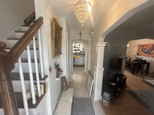 corridor with light tile patterned floors and an inviting chandelier