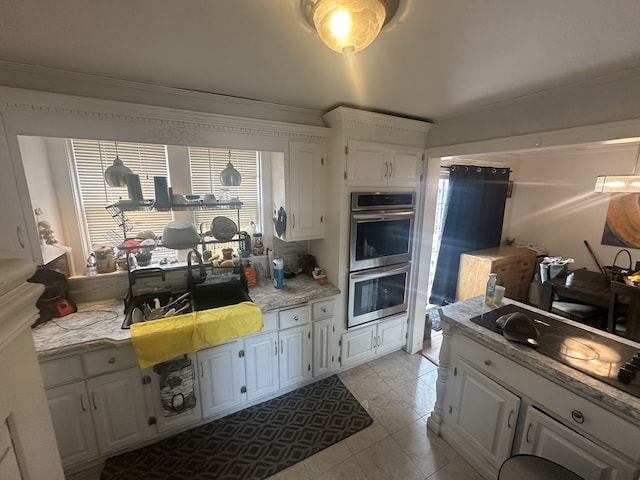 kitchen with stainless steel double oven, white cabinetry, light stone counters, and light tile patterned floors