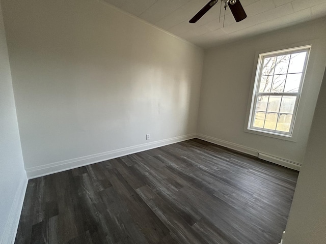 spare room with dark wood-type flooring, ceiling fan, and a baseboard heating unit