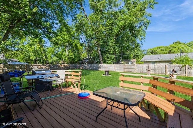 wooden deck featuring a yard and a grill