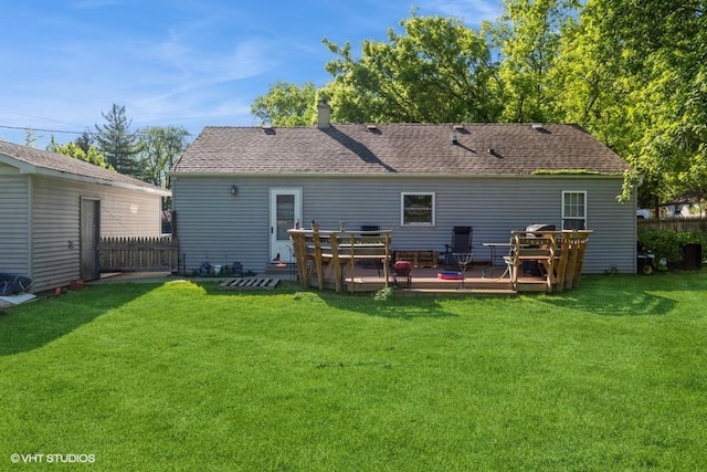 back of house featuring a lawn and a deck