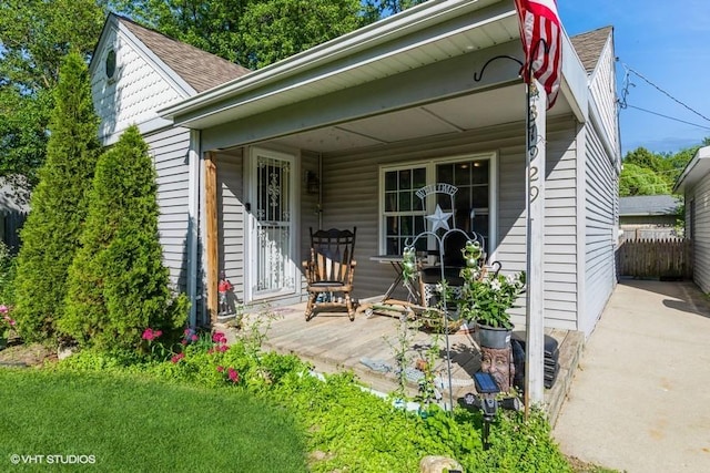 rear view of property featuring covered porch