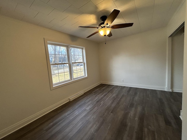 unfurnished bedroom featuring dark hardwood / wood-style floors, crown molding, ceiling fan, and a baseboard heating unit