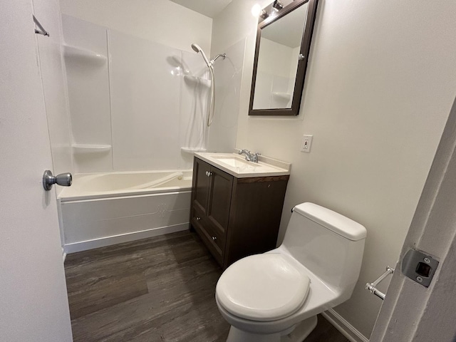 full bathroom featuring washtub / shower combination, wood-type flooring, vanity, and toilet