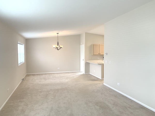 carpeted spare room with a chandelier and lofted ceiling